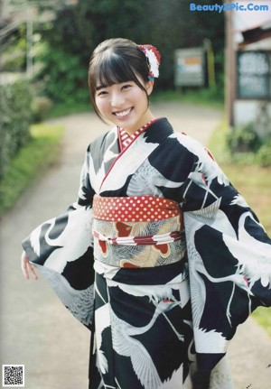 A woman in a kimono sitting on a green couch.