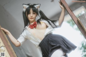 A woman with long black hair wearing a cat ears headband.