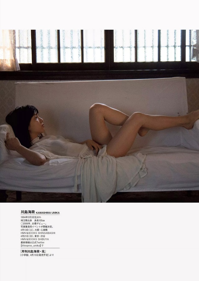 A woman laying on a bed with her legs up.