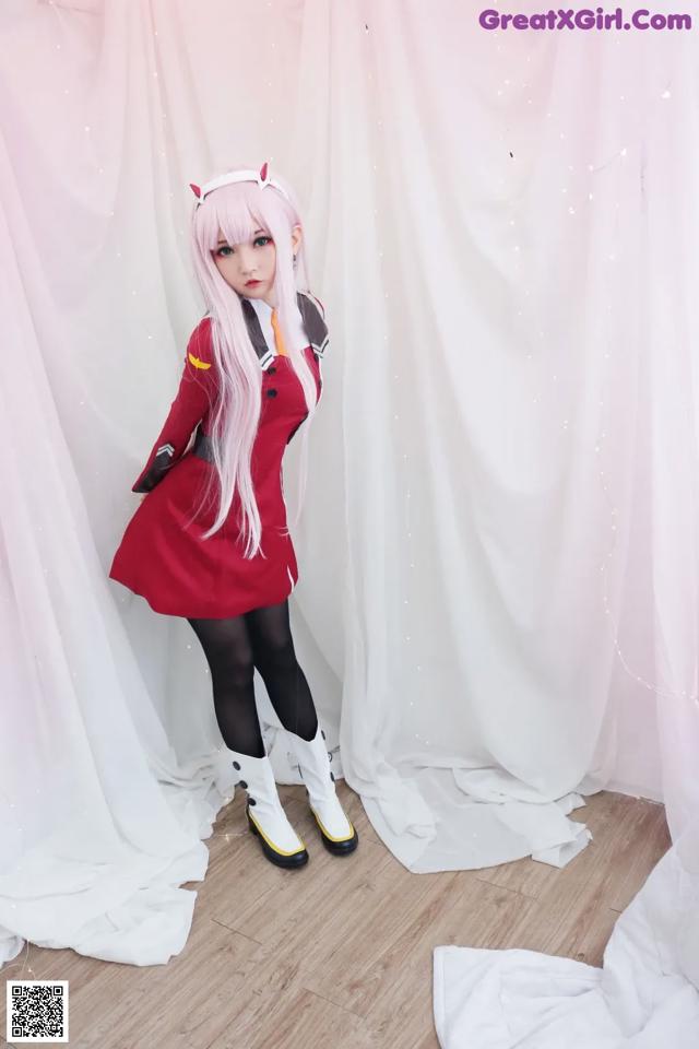 A woman in a red dress and white boots posing for a picture.