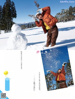A woman laying in the snow with her feet up in the air.