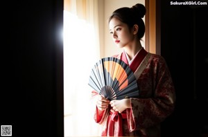 A nude asian woman laying on a colorful blanket.