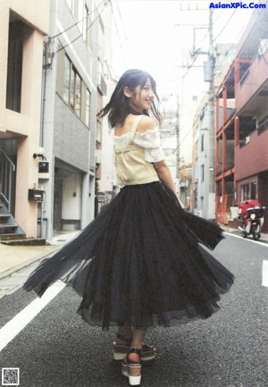 A woman in a white dress standing in front of some stairs.