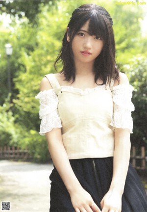 A woman in a white dress standing in front of some stairs.