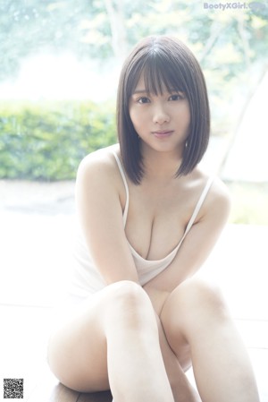 A naked asian woman laying on a bed.