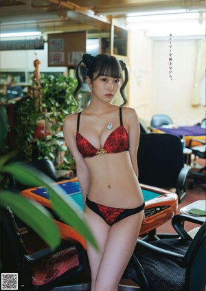 A woman in a red and black lingerie posing for a magazine.