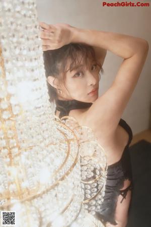 a woman sitting on top of a chair next to a chandelier