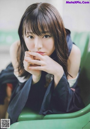 A woman sitting on a bench by the water.