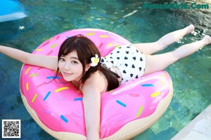 A woman in a white bikini sitting on a couch.