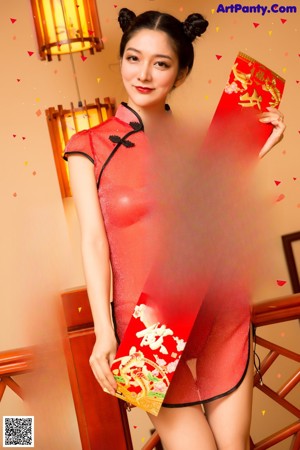 A woman in a red dress sitting on a set of stairs.