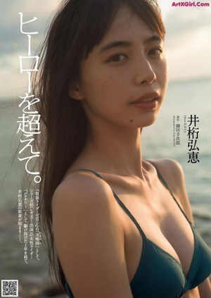 A woman in a green tank top standing on a beach.