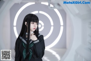 A woman in a school uniform standing in front of a circular light.