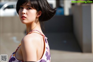 A naked asian woman sitting on a counter in a bathroom.