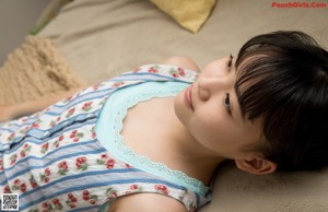 A young girl laying on a bed smiling at the camera.