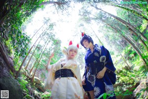 A couple of women sitting on top of a tree.