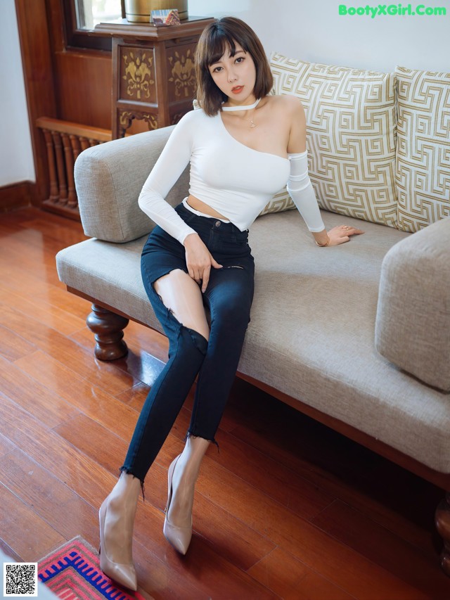 A woman sitting on a couch in a living room.