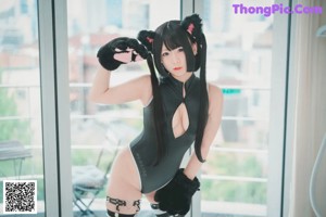 A woman in a black and white outfit with cat ears.